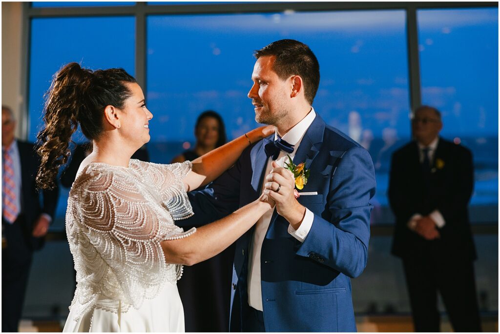 A bride and groom smile during their first dance in Watermark Asbury Park.