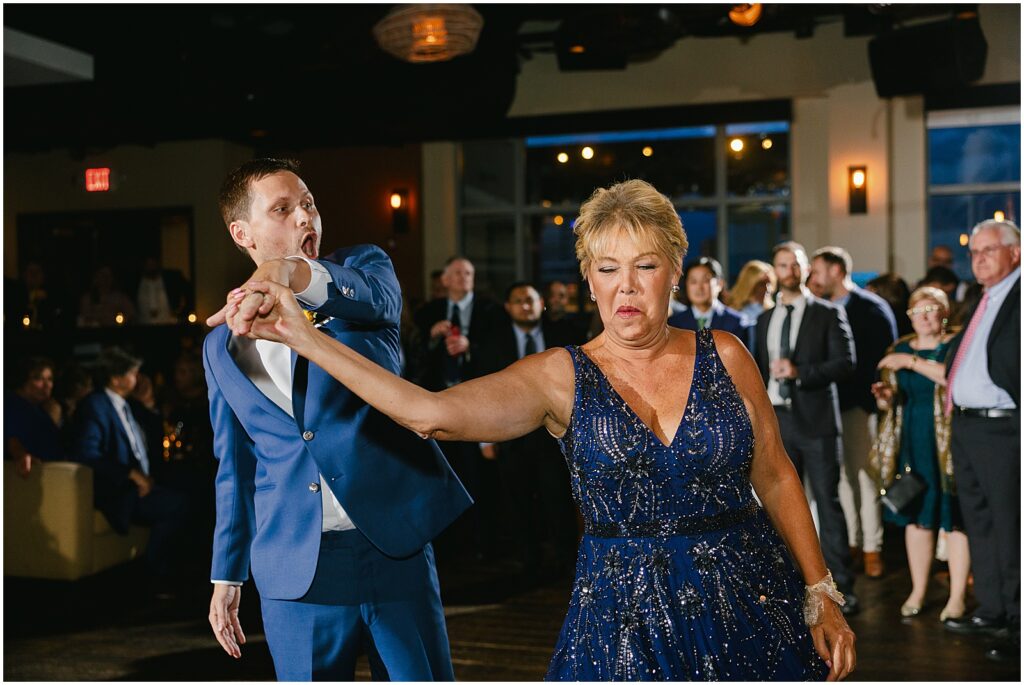A groom dances with his. mother.