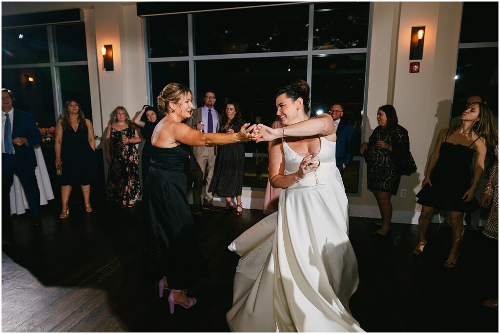 A bride spins with a wedding guest during her reception.