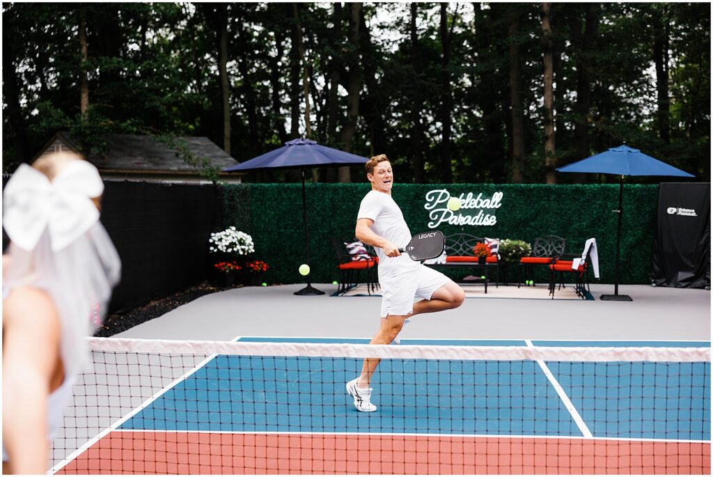 A woman leaps to hit a ball during a pickleball engagement session.