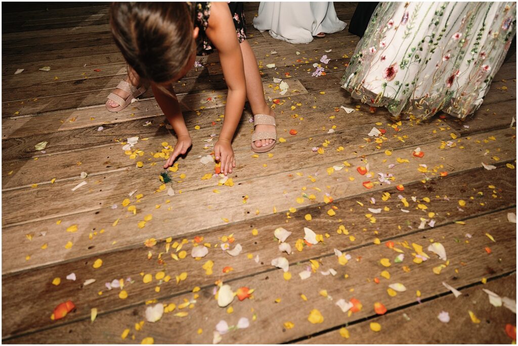 Children scoop up flower petals from the dance floor.