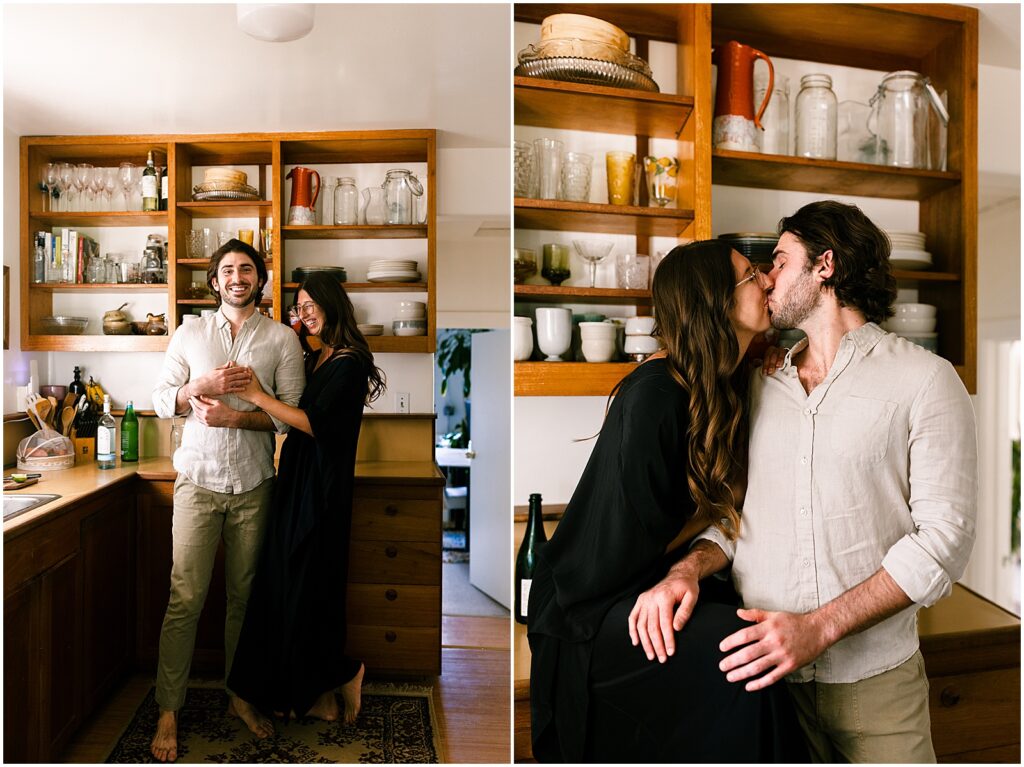 A man and woman kiss in a kitchen during a San Diego engagement photo session.