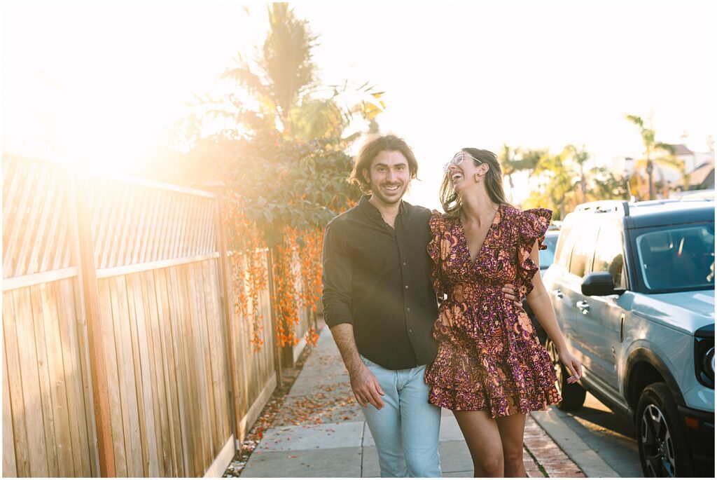 A man and woman laugh as a San Diego wedding photographer takes their picture.