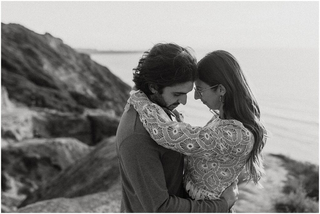 A man and woman embrace on a San Diego beach.