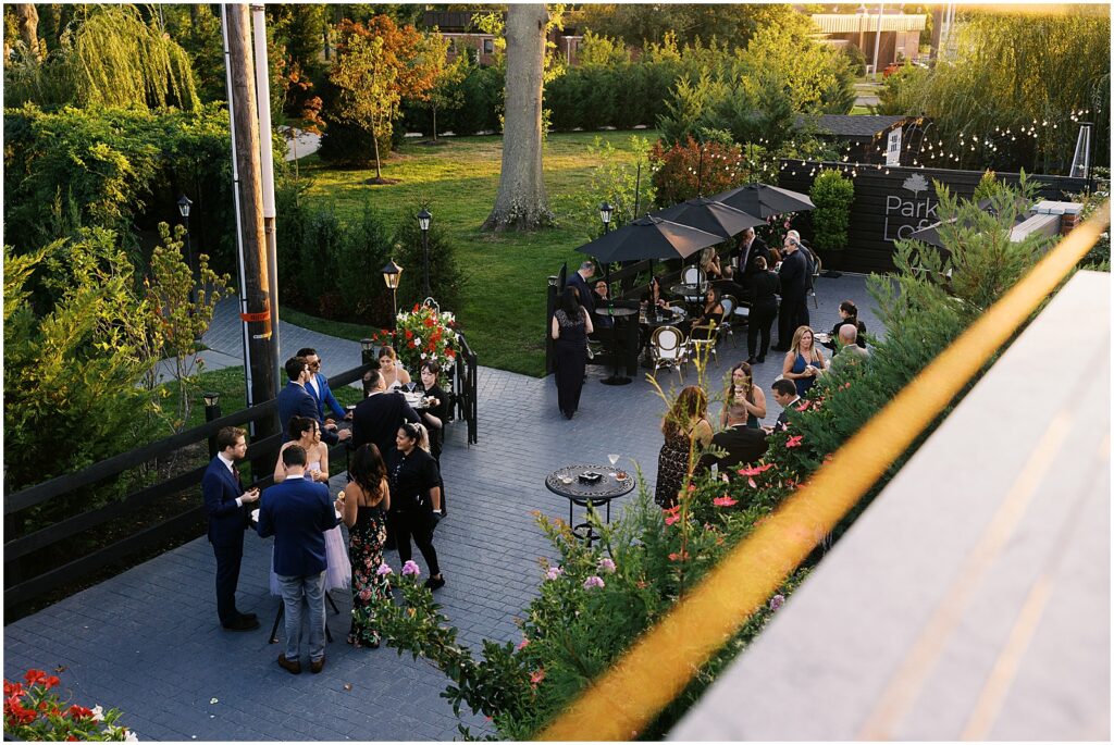 Wedding guests gather on a patio for cocktail hour.